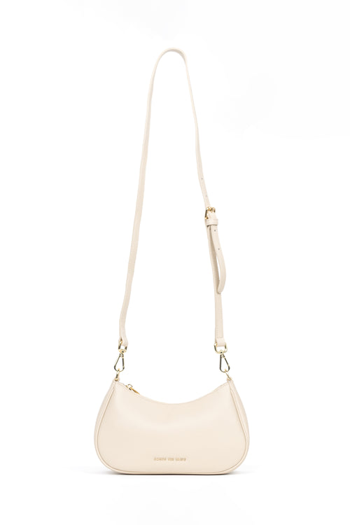A cream-colored faux leather crescent-shaped shoulder bag with a matching adjustable shoulder strap and gold-tone hardware, shown on a plain white background.