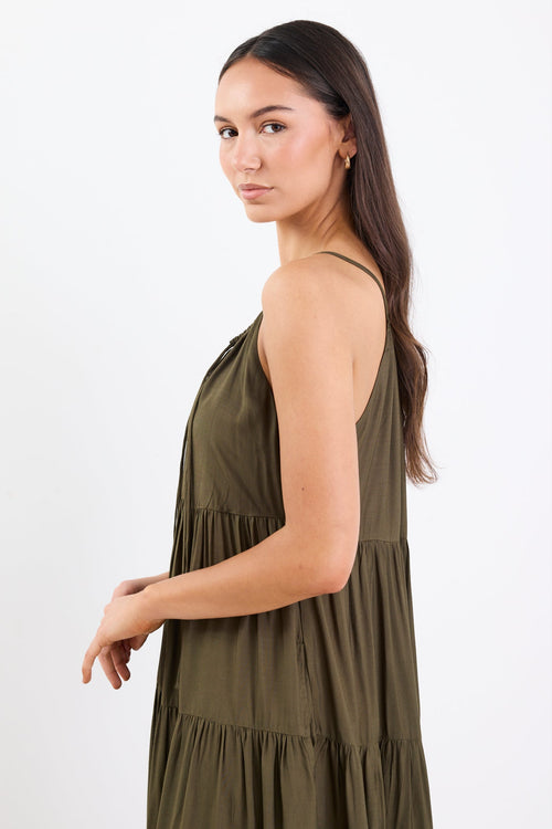 Woman wearing an olive green tiered maxi dress with thin adjustable straps, a V-neckline, and relaxed fit.