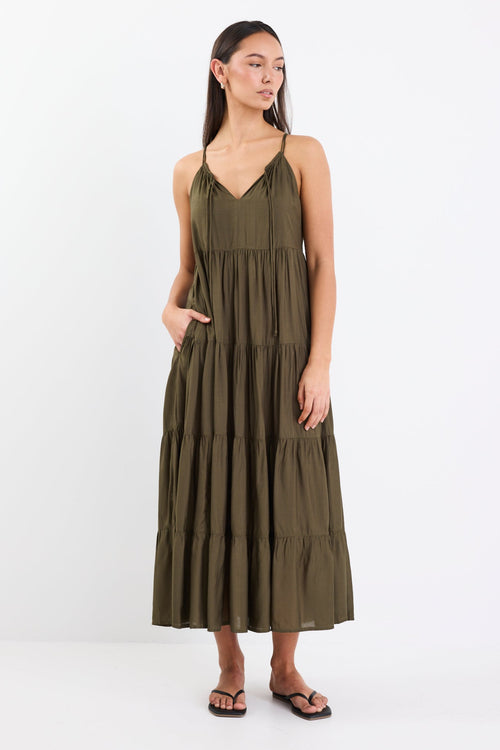 Woman wearing an olive green tiered maxi dress with thin adjustable straps, a V-neckline, and relaxed fit.