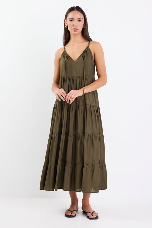 Woman wearing an olive green tiered maxi dress with thin adjustable straps, a V-neckline, and relaxed fit.