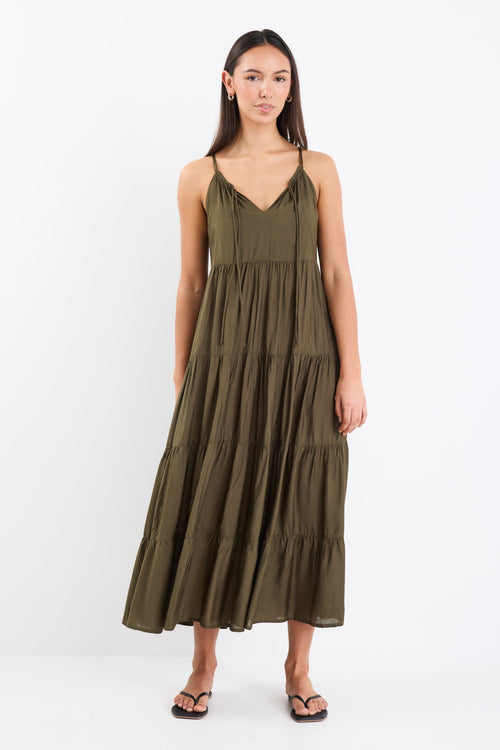 Woman wearing an olive green tiered maxi dress with thin adjustable straps, a V-neckline, and relaxed fit.