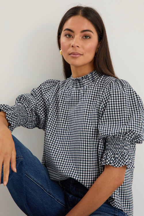 model wearing gingham shirred top. 