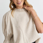 model wears a beige linen blouse