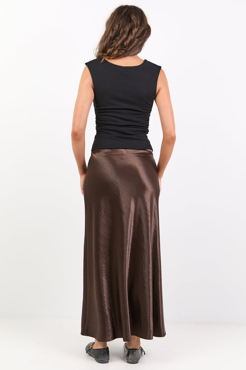 Woman wearing a black top and brown skirt on a white background