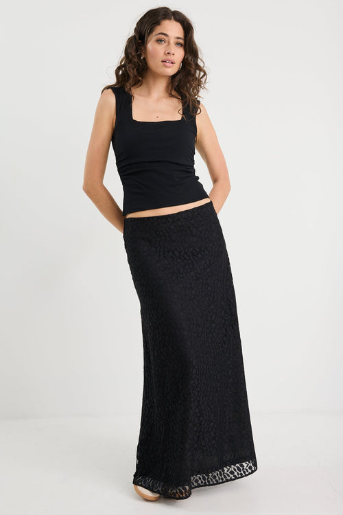 Woman wearing a black lace skirt and black tank