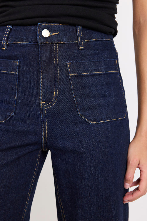 Close-up of dark blue jeans with a white background