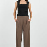 Women wearing black tank and brown pants.