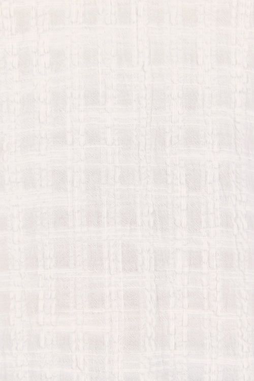 A close-up of a light off-white textured fabric with a subtle woven grid pattern.