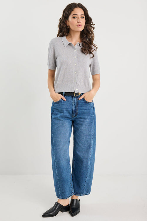 Woman wearing grey knit and blue jeans