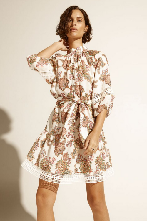 model wears cream floral mini dress