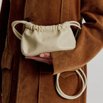 model wears a cream mini bag