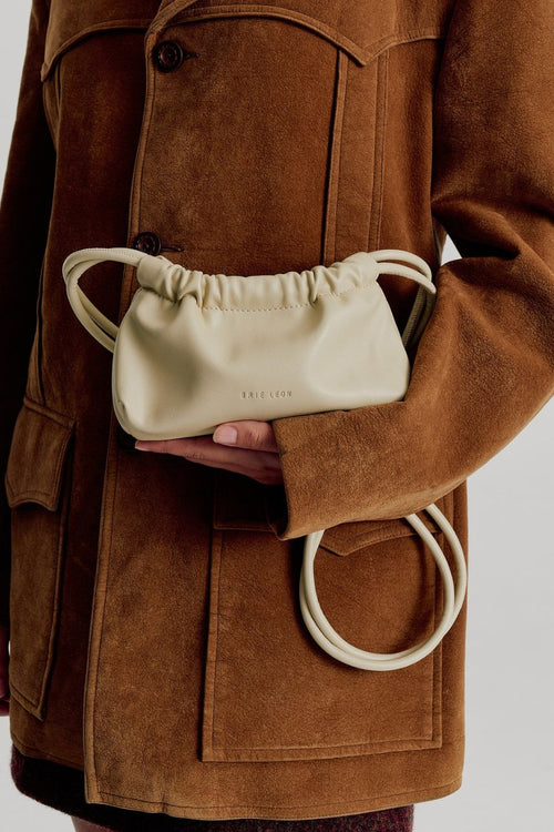 model wears a cream mini bag