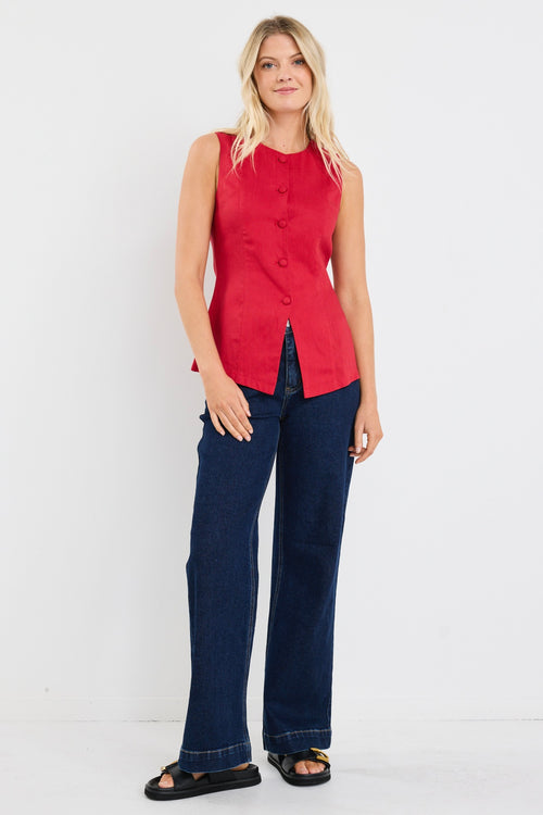 model wears a red linen vest with dark jeans