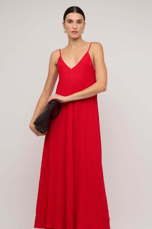 Bright red textured maxi dress with thin spaghetti straps and a deep V-neckline, styled in a relaxed fit, worn by a model against a neutral background.