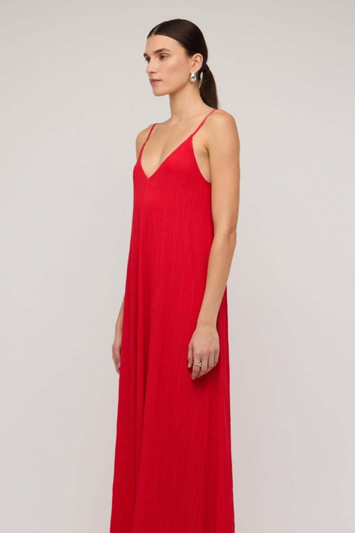 Bright red textured maxi dress with thin spaghetti straps and a deep V-neckline, styled in a relaxed fit, worn by a model against a neutral background.