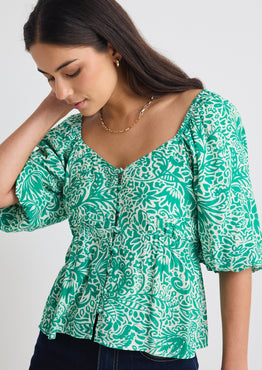 model wears a green floral blouse 