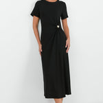 Woman wearing a black dress with a knot detail on a white background