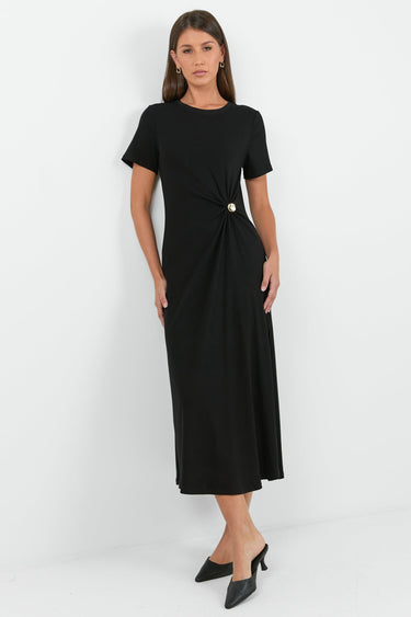 Woman wearing a black dress with a knot detail on a white background