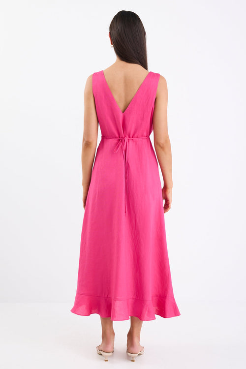 Woman wearing a pink dress with a deep V-neck and belt on a white background