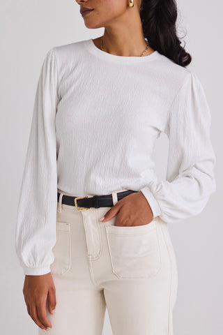 model wears a white long sleeve top