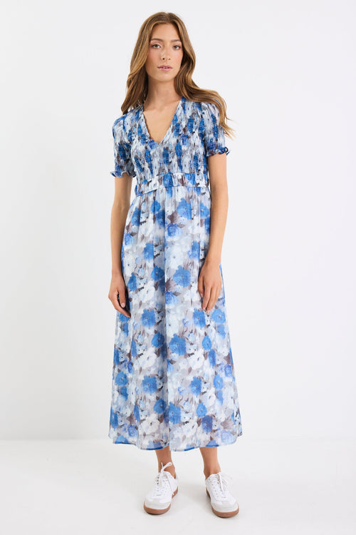 Woman wearing a blue floral dress on a white background