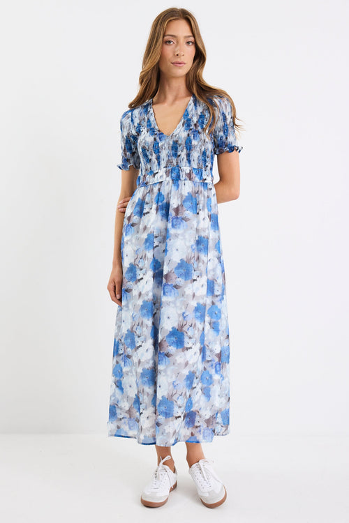 Woman wearing a blue floral dress on a white background