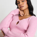 Model wears a pink long sleeve knit top