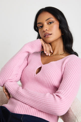 Model wears a pink long sleeve knit top