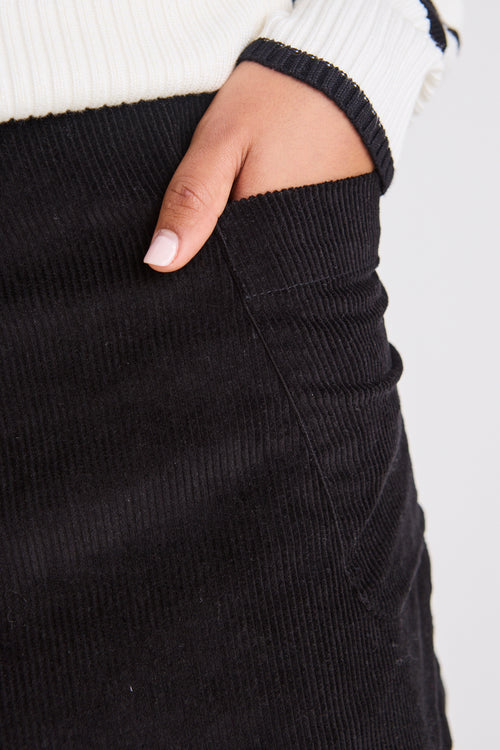 model wears a black mini skirt