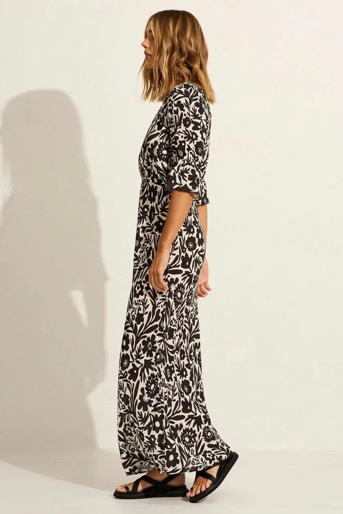 model wears a black floral maxi dress