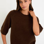 Woman wears a chocolate knit tee