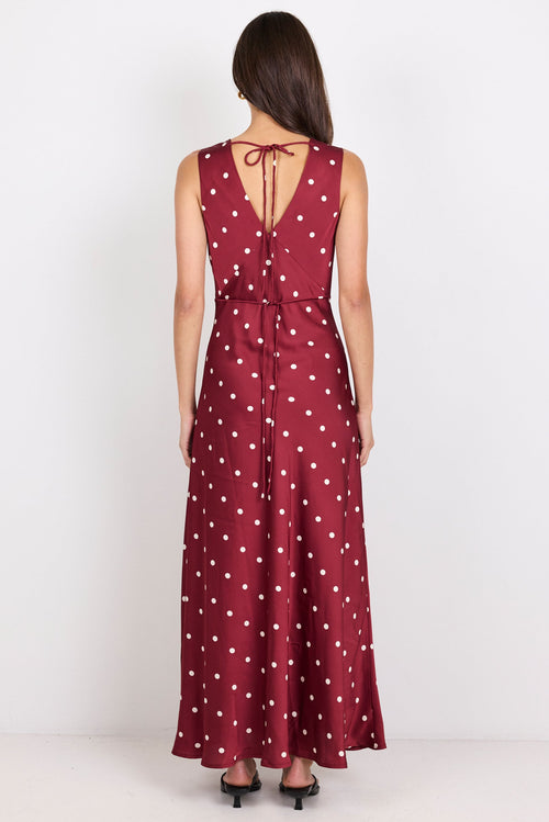 Woman wearing a red polka dot dress on a white background
