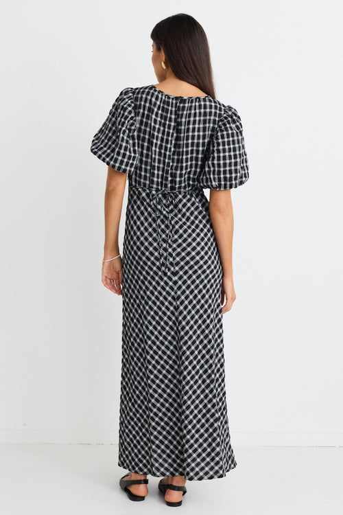 model wears a black and white check maxi dress