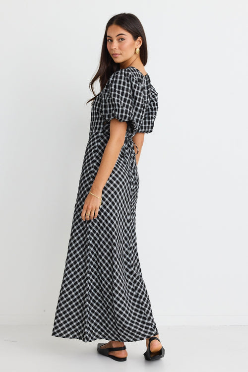 model wears a black and white check maxi dress