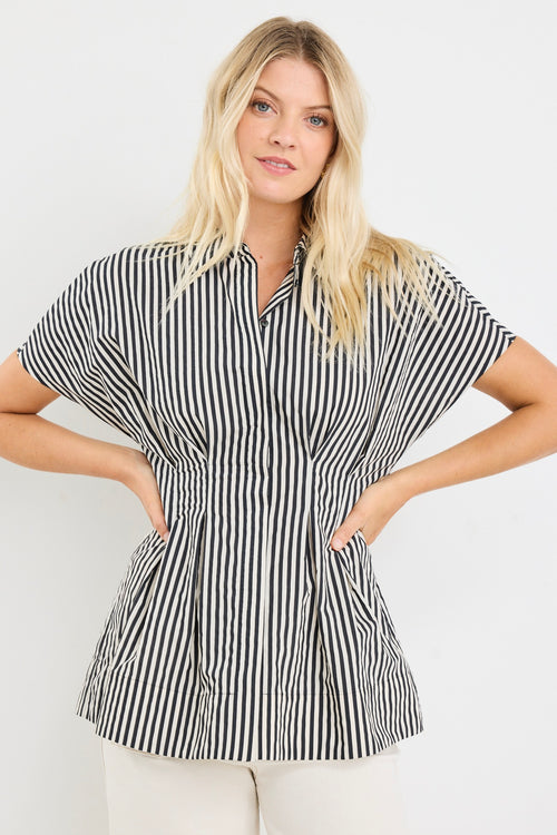 model wears a black and white short sleeve corset shirt with white jeans