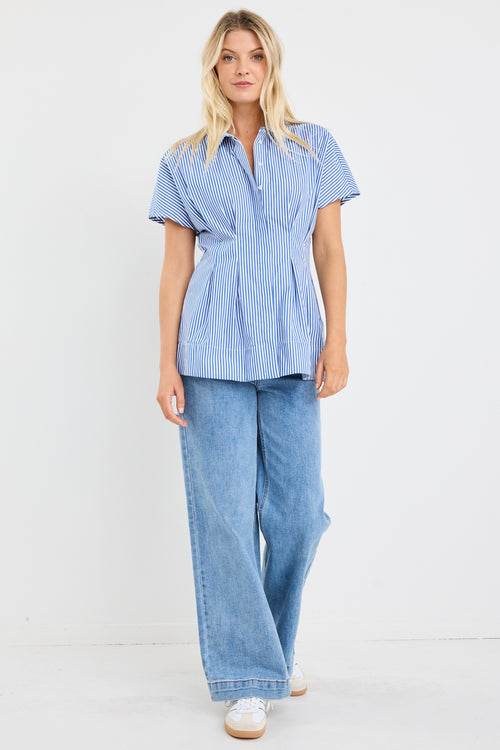 model wears a blue stripe corset blouse with blue jeans