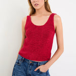woman wearing a red knit top and blue jeans
