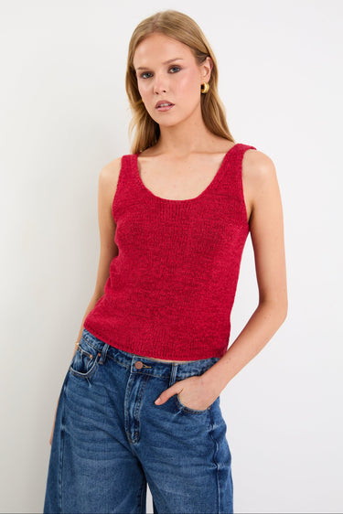 woman wearing a red knit top and blue jeans