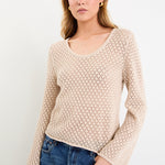 Woman wearing a light crochet knit and blue jeans