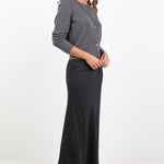 Woman wearing a gray cardigan and black pants on a white background