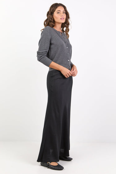 Woman wearing a gray cardigan and black pants on a white background