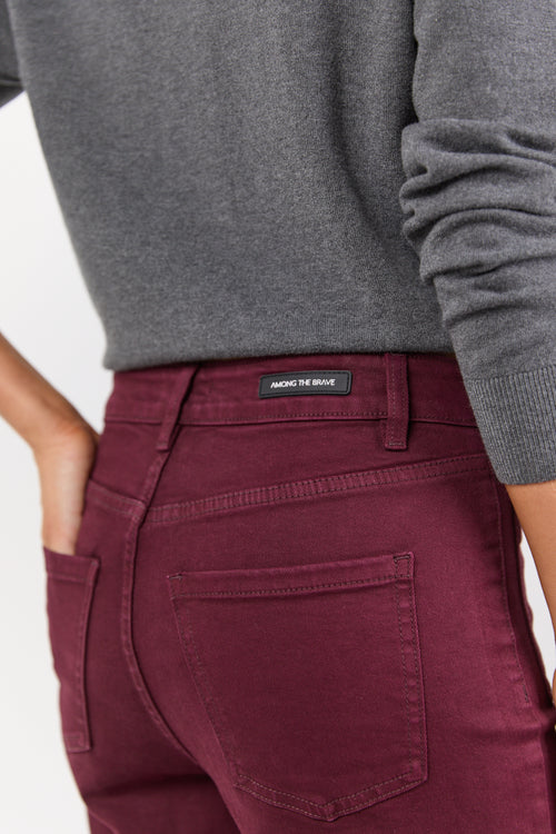 Maroon pants with a brand label on a white background