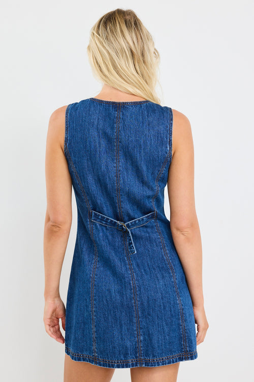 model wears a blue denim mini dress