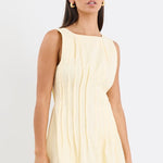 Woman wearing a light yellow dress on a white background