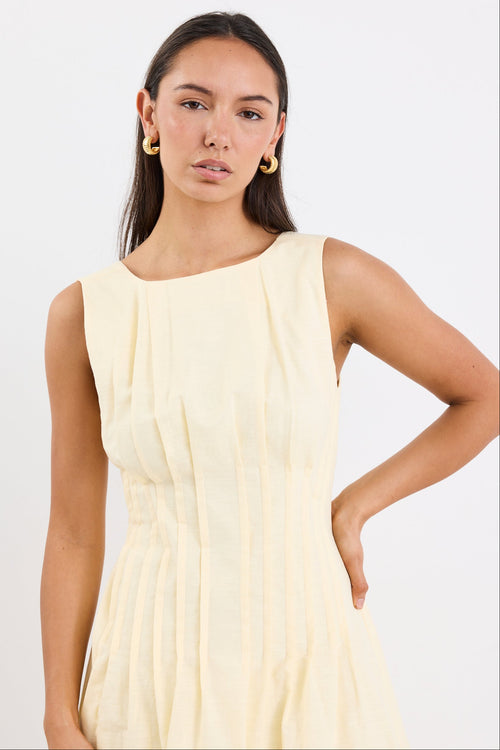 Woman wearing a light yellow dress against a white background