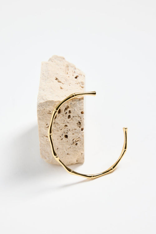bamboo-inspired gold-plated cuff bangle with textured design, photographed flat against a white background.