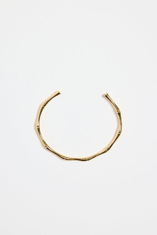 bamboo-inspired gold-plated cuff bangle with textured design, photographed flat against a white background.