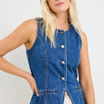 model wears a blue denim vest with a beige linen midi skirt