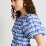 model wears a blue check frill top