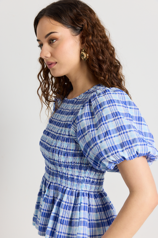 model wears a blue check frill top